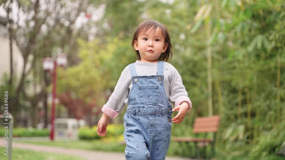 4k slow motion lovely asian baby girl walking in the urban park 4k slow motion lovely asian baby girl walking in the urban park