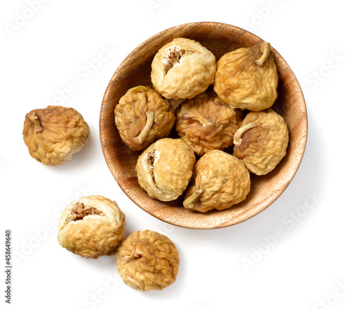 close up of dried fig fruits in the wooden bowl, isolated on the white background, top view