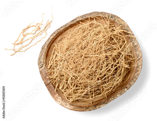 dried vetiver roots in the wooden bowl, isolated on the white background, top view