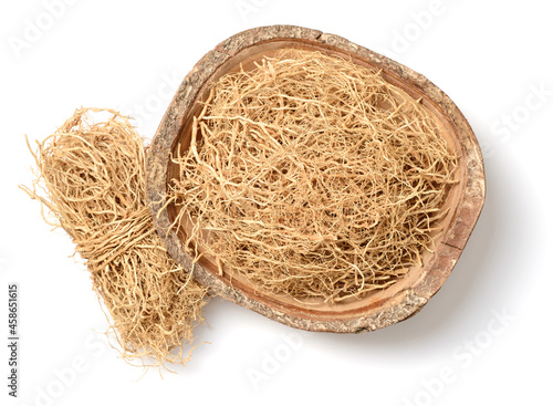 dried vetiver roots in the wooden bowl, isolated on the white background, top view