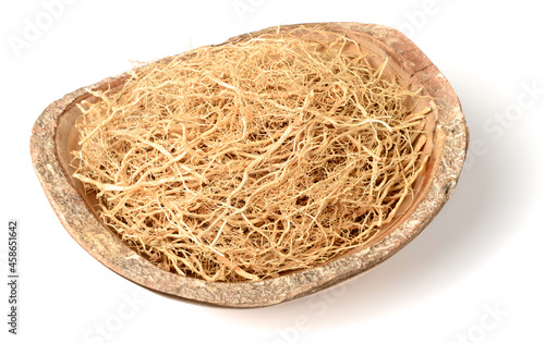 dried vetiver roots in the wooden bowl, isolated on the white background