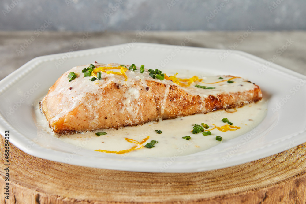 Fillet of salmon fish in bechamel sauce with orange zest and green onions. French cuisine Gourmet food