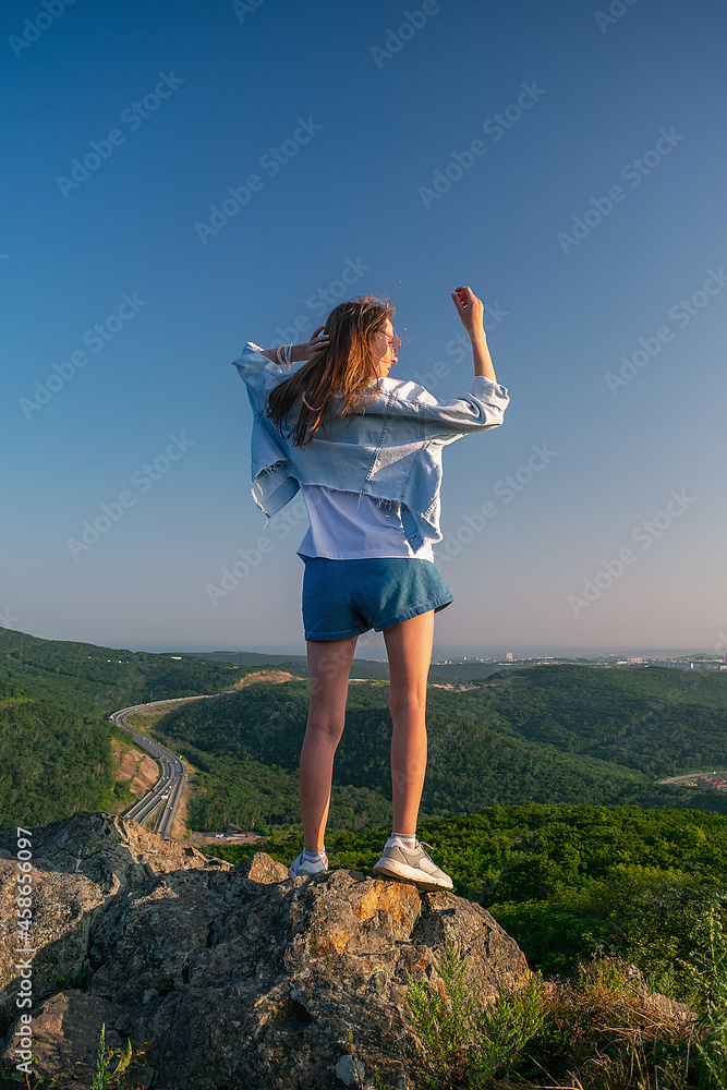 Girl in shorts on the top of the mountain