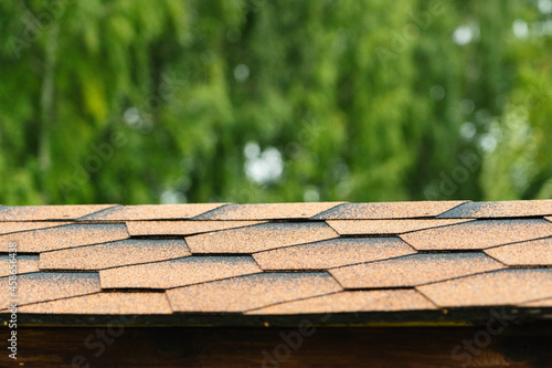 the texture of the roof of the gazebo, covered with soft bitumen tiles of orange-brown color close-up