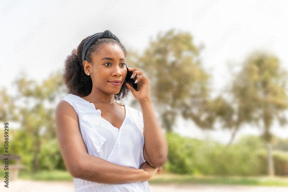Young African American woman talking with her phone in the park Young African American woman talking with her phone in the park