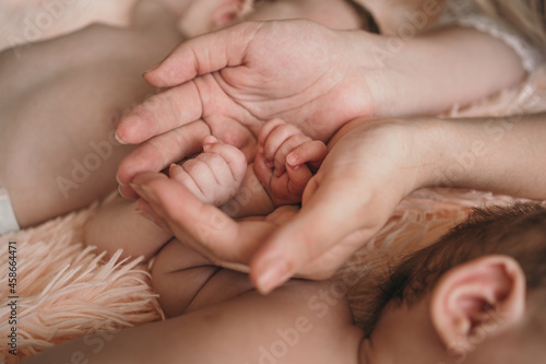 Parents gently hold small children's hands. Close-up of the baby's hand and parents. Parents care about their baby. Small children's pens