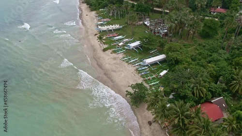 Nice view of small beach crashing to the white beach seashore, green trees around the resorts at the front of the turquoise sea water photo