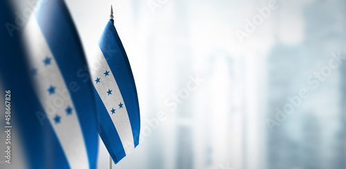 Small flags of Honduras on a blurry background of the city