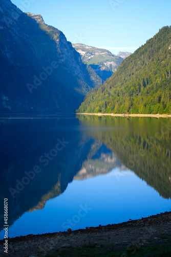 Lake Klöntal at a beautiful late summer morning with reflections in calm water. Photo taken September 4th, 2021, Klöntal, Switzerland.