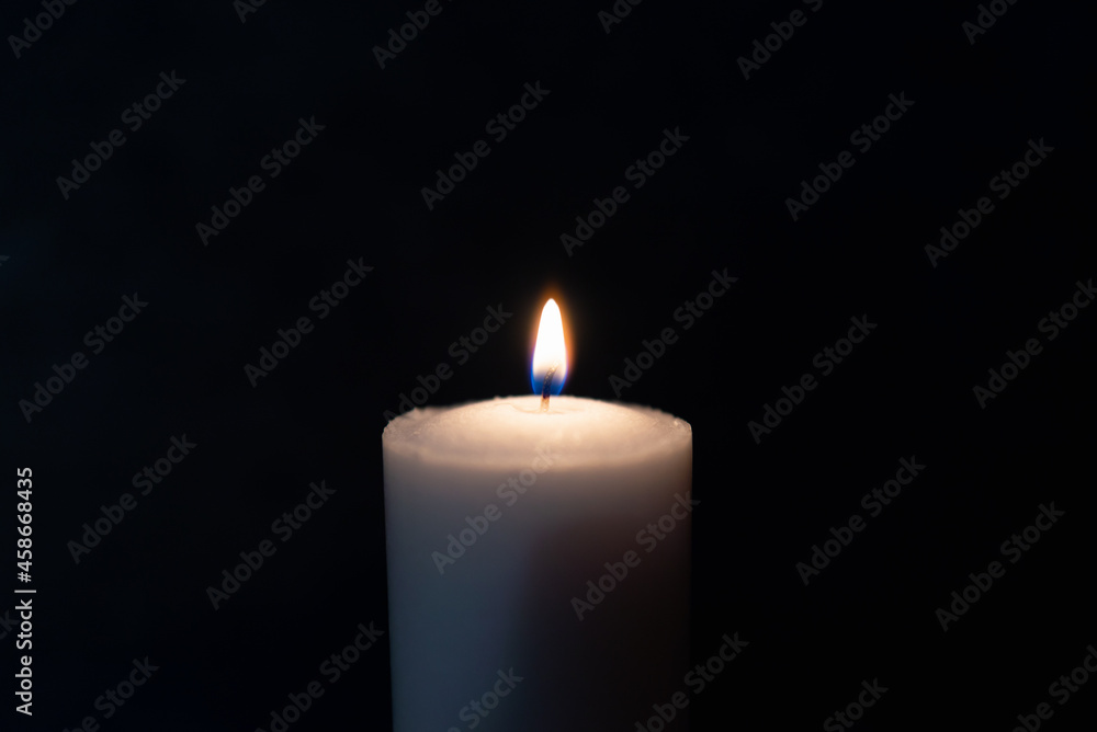One single light candle burning brightly in the black background.Spiritual candle yellow flame. Flame of candle in the darkness.Copy space. One single light candle burning brightly in the black background.Spiritual candle yellow flame. Flame of candle in the darkness.Copy space.