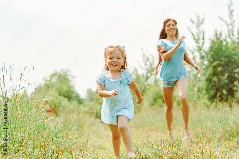 daughter runs towards her mother on the grass daughter runs towards her mother on the grass