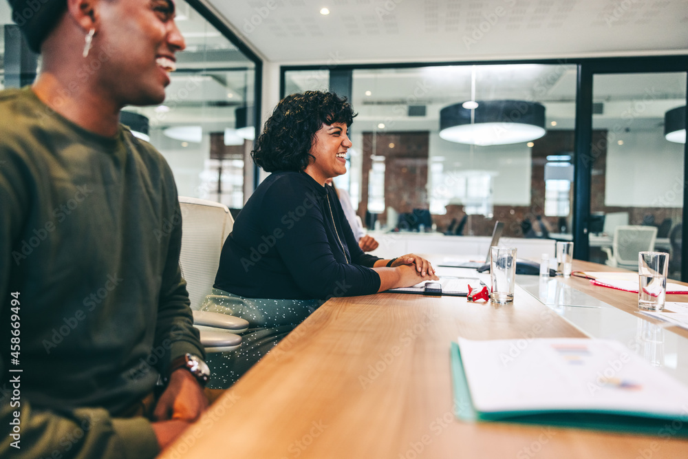 Modern businesspeople smiling in a boardroom Modern businesspeople smiling in a boardroom