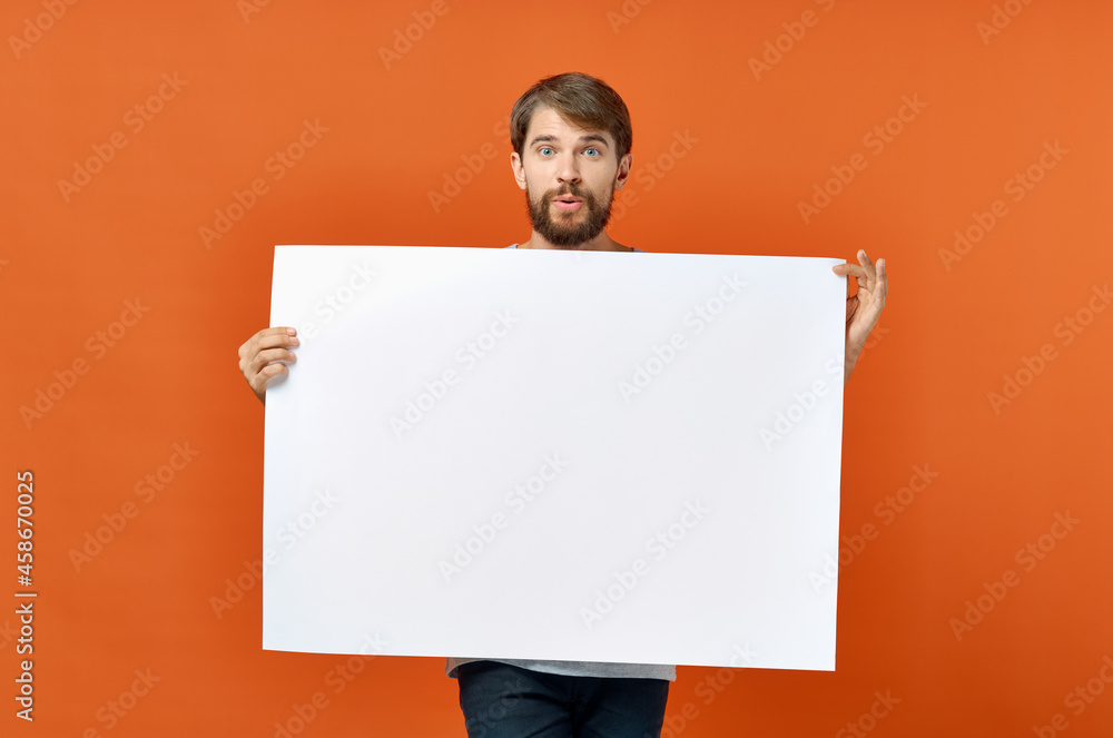 funny man holding a mockup poster discount orange background funny man holding a mockup poster discount orange background