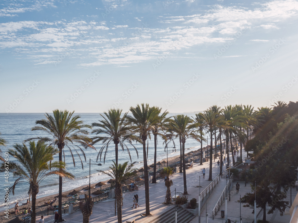 Sunset on the promenade with palm trees and Mediterranean sea. Marbella, Costa del sol, Andalusia