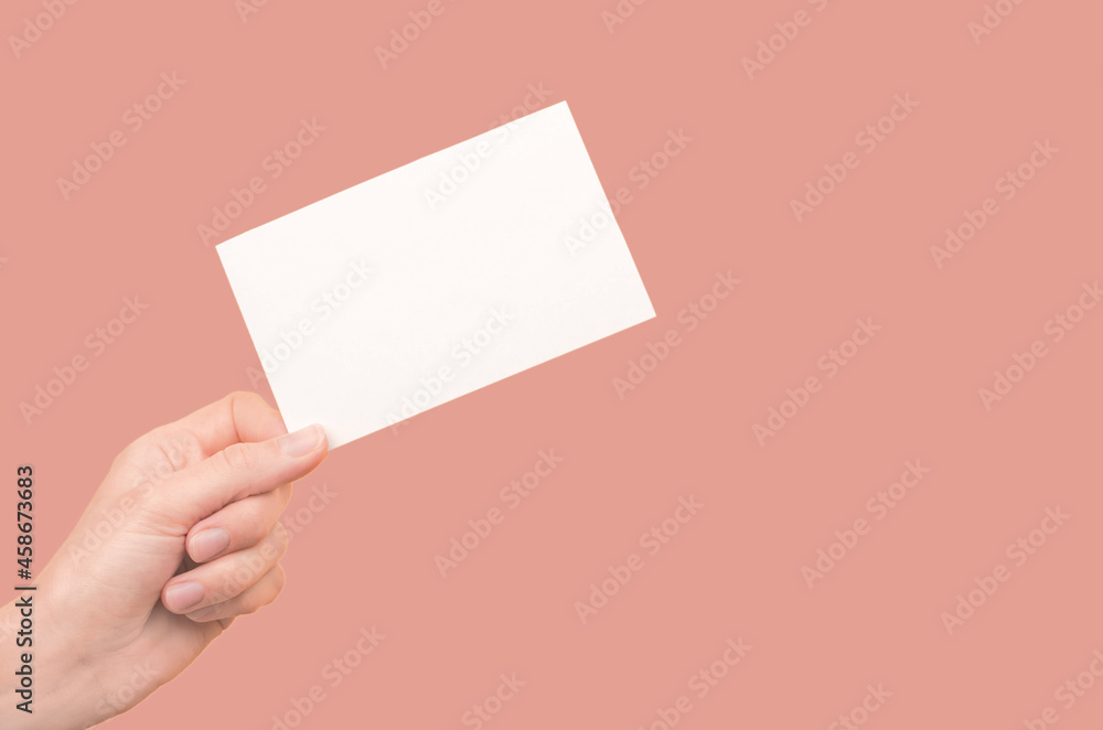 Female hands with business card. Female hand holding a white card on a coloured background Female hands with business card. Female hand holding a white card on a coloured background