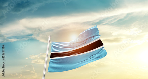 Botswana national flag cloth fabric waving on beautiful sky - Image