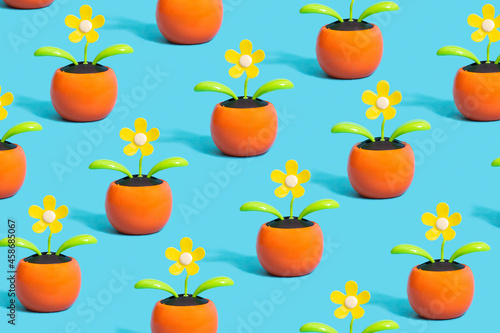 Environmental issues inspired pattern concept. Artificial yellow flowers with small solar cell within against blue background