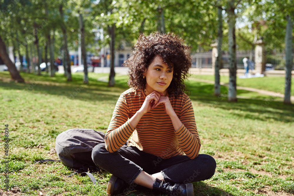 Cute young woman looking thoughtful in a park Cute young woman looking thoughtful in a park