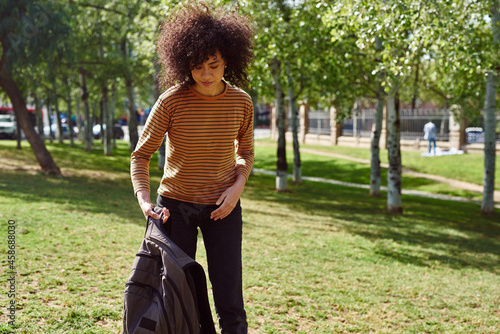 Cute young woman putting down her backpack