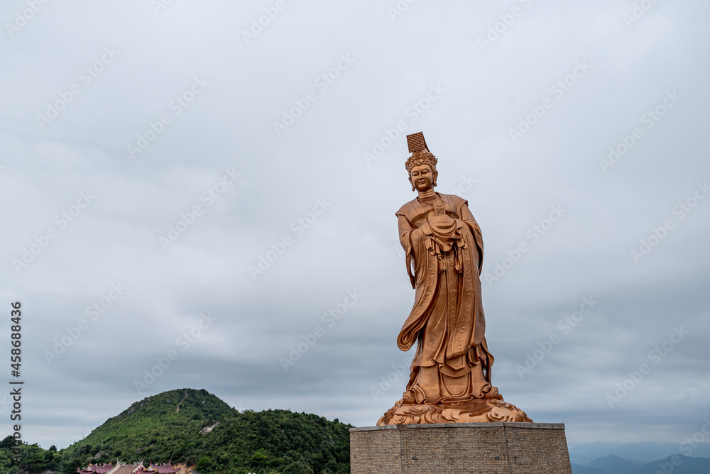 The bronze statue of Chinese religious goddess in cloudy weather