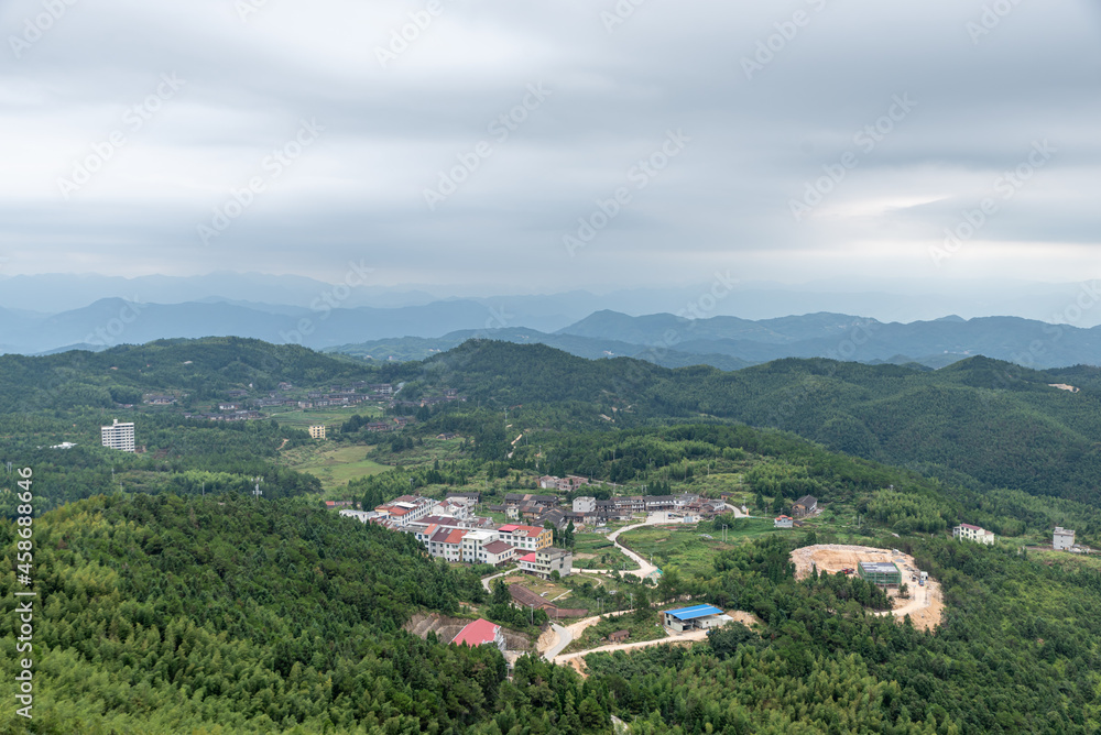A country surrounded by forests on a cloudy day A country surrounded by forests on a cloudy day