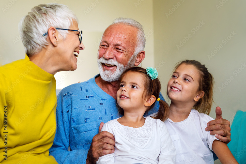 Happy mature couple having fun in love with their grandchildren