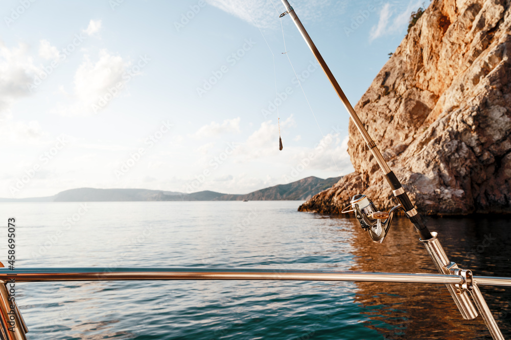 Fishing rod on a sailboat on the background of the sea Fishing rod on a sailboat on the background of the sea