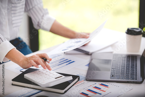 businessman or accountant who are using a calculator to calculate business data Accounting documents and laptop computer at the office business idea