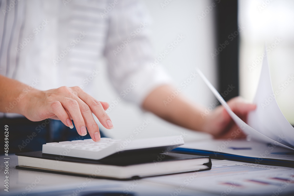 businessman or accountant who are using a calculator to calculate business data Accounting documents and laptop computer at the office business idea businessman or accountant who are using a calculator to calculate business data Accounting documents and laptop computer at the office business idea