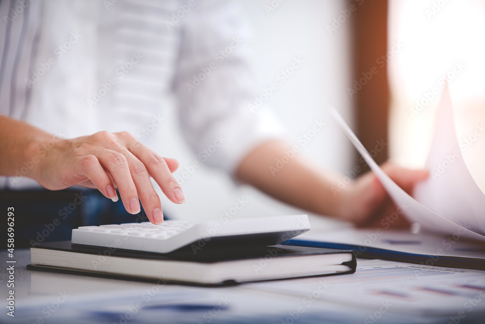 businessman or accountant who are using a calculator to calculate business data Accounting documents and laptop computer at the office business idea businessman or accountant who are using a calculator to calculate business data Accounting documents and laptop computer at the office business idea