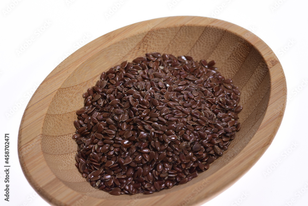 Linseed on a wooden bowl against a white background. Food. Spices. Linseed on a wooden bowl against a white background. Food. Spices.