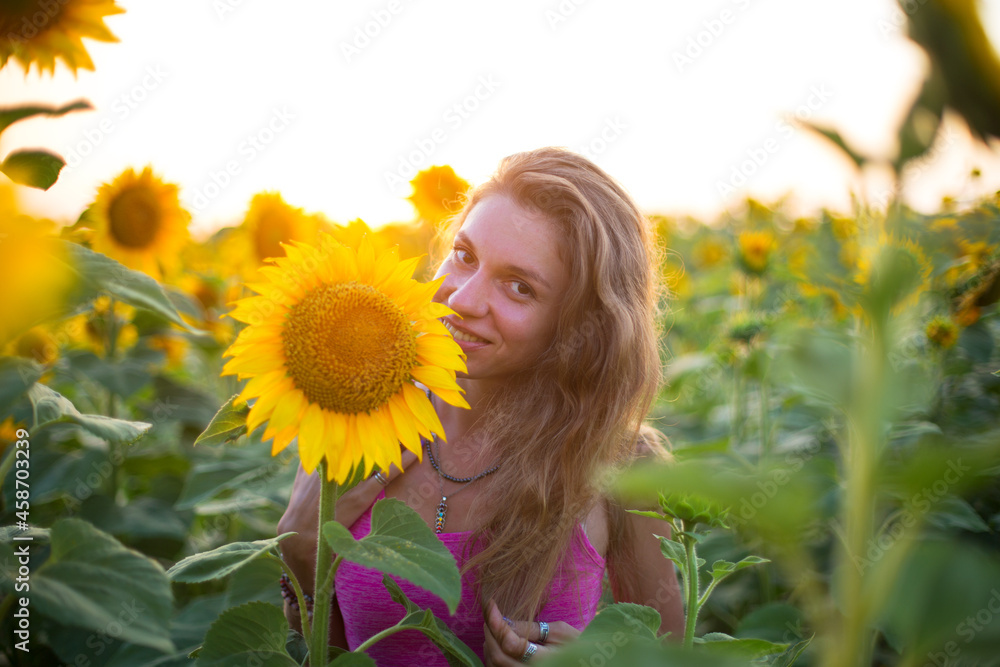 thin girl in magenta dress is in the sunflowers in soft sunlight thin girl in magenta dress is in the sunflowers in soft sunlight