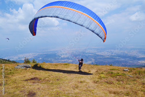 Paraglider Flying in the Blue Cloudy Sky