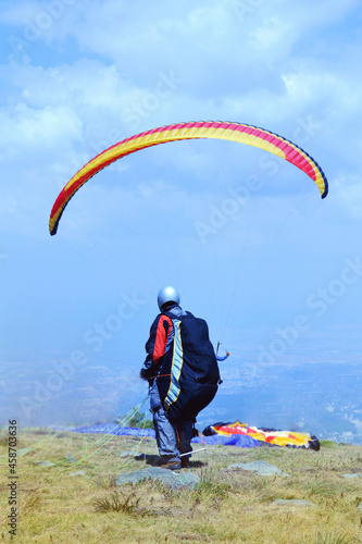 Paraglider Flying in the Blue Cloudy Sky