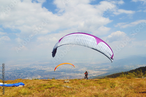 Paraglider Flying in the Blue Cloudy Sky