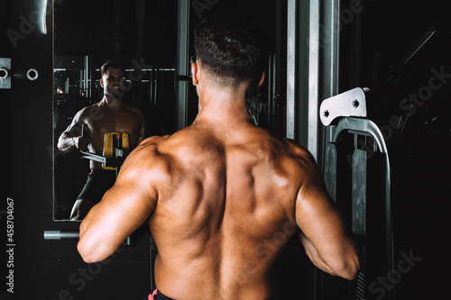 Quadro su tela Strongman looking in the mirror while exercising in a gym