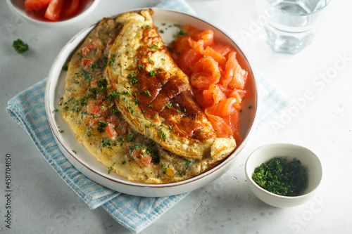Traditional homemade omelette with tomatoes and salmon