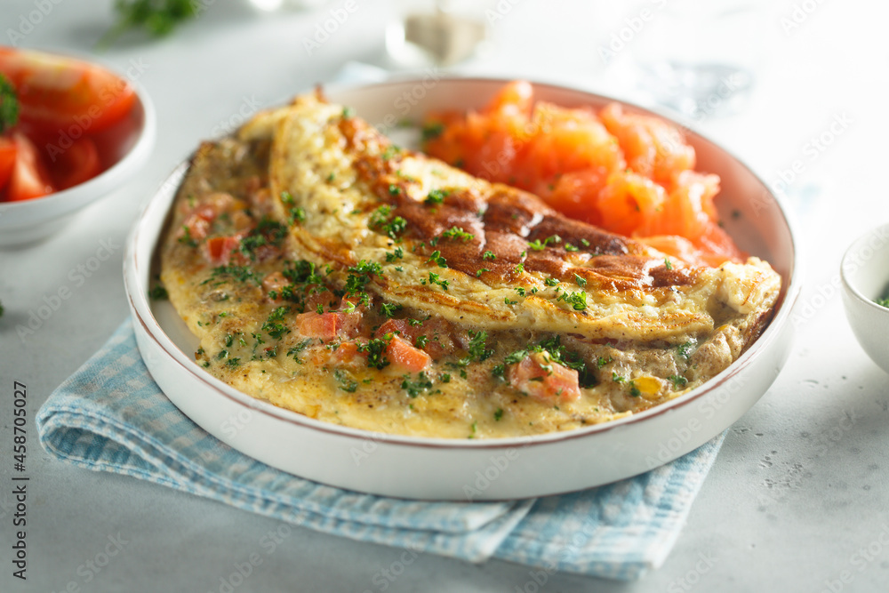 Traditional homemade omelette with tomatoes and salmon Traditional homemade omelette with tomatoes and salmon
