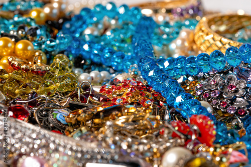 necklaces, earrings, bracelets, pearls, beads and various colored gemstones as a background