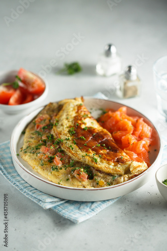 Traditional homemade omelette with tomatoes and salmon photo