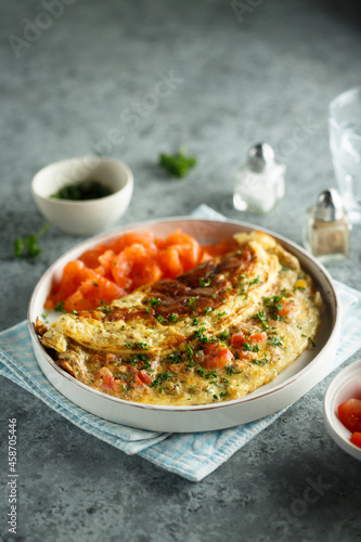 Traditional homemade omelette with tomatoes and salmon