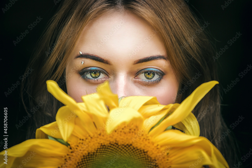 portrait of young beautiful girl with yellow sunflower and green eyes portrait of young beautiful girl with yellow sunflower and green eyes