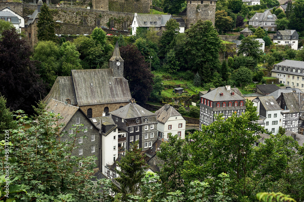 Old half-timbered houses in a village in a valley between the hills.
