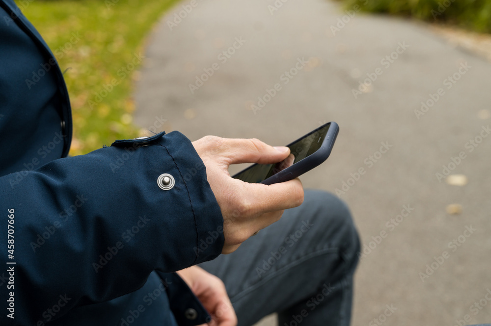 Close-up of the phone in the hands of a man. Autumn Park. Close-up of the phone in the hands of a man. Autumn Park.
