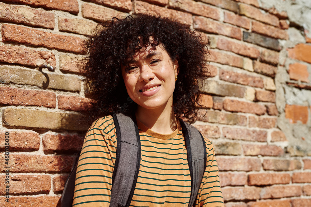 Beautiful young woman smiling at you outdoors