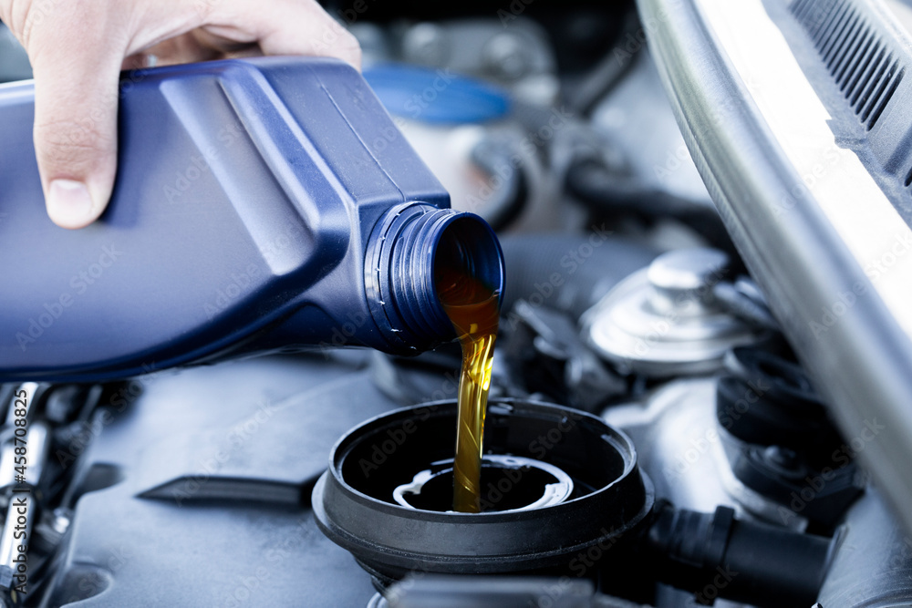 Motor oil pouring. Refueling and pouring oil quality into the engine