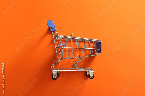 shopping cart, empty grocery cart on orange background