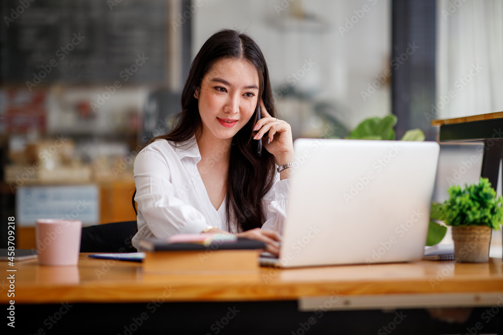 Portrait of Asian young Businesswoman talking on cell phone working on tablet computer in the office hallway, blur background.
Portrait of Asian young Businesswoman talking on cell phone working on tablet computer in the office hallway, blur background.