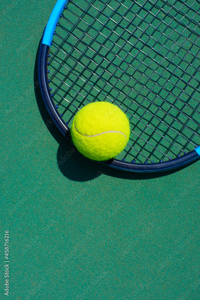 Tennis racquet and ball lying on the court. Healthy lifestyle concept