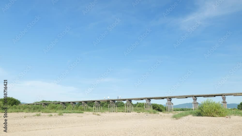 Midsummer, dried up river water and an old bridge.